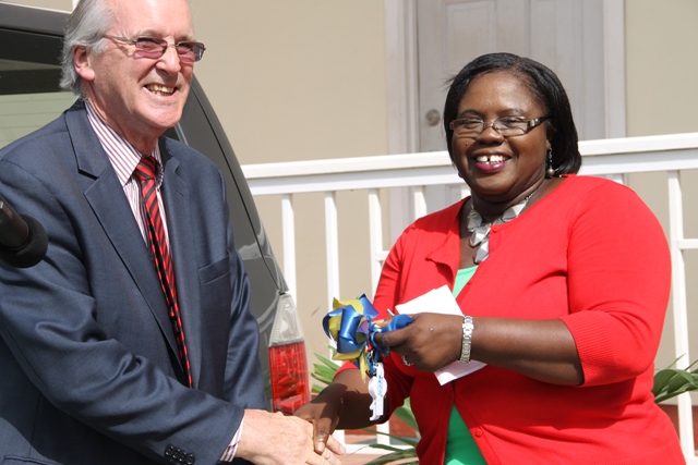 Director of Trust Services (Nevis) Ltd. Paul Mason hands over keys to the new Suzuki bus for use in the Department of Community Development to Minister of Community Development Hazel Brandy-Williams on June 05, 2015